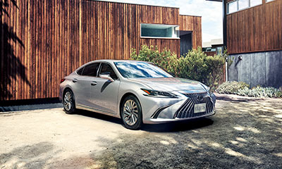 A stationary ES shown from an angle, with a modern wooden house behind it.