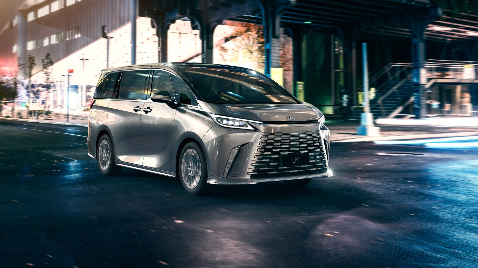 Front on view of a silver LM driving at nighttime.