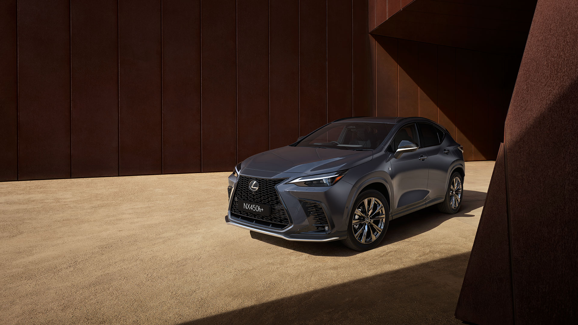 Sonic Chrome NX 450h+ shown parked in front of an abstract timber geometric building. 