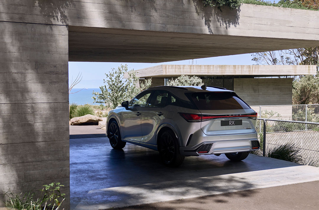 A silver Lexus RX is parked in the carport of a luxury home