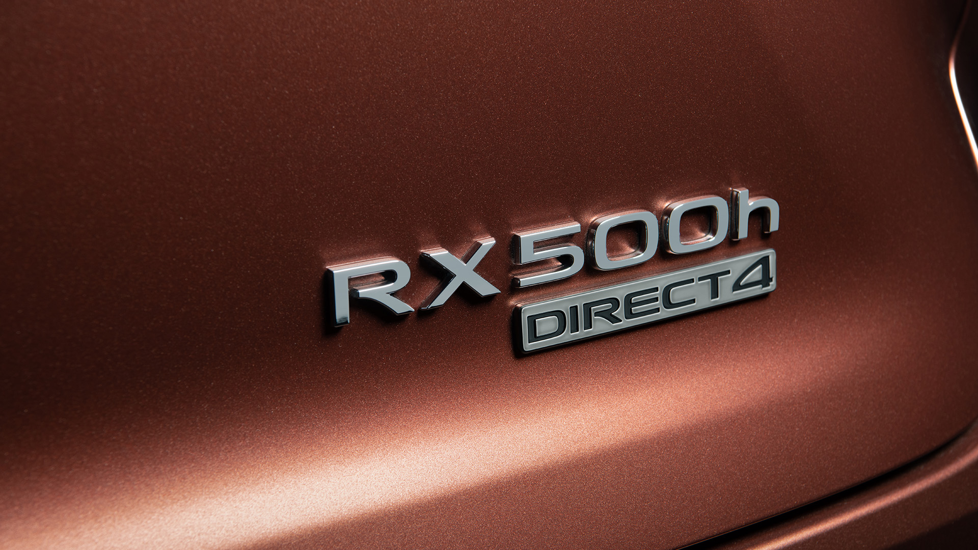 A close up of the badge on a copper colored RX that Reads RX500h Direct 4.