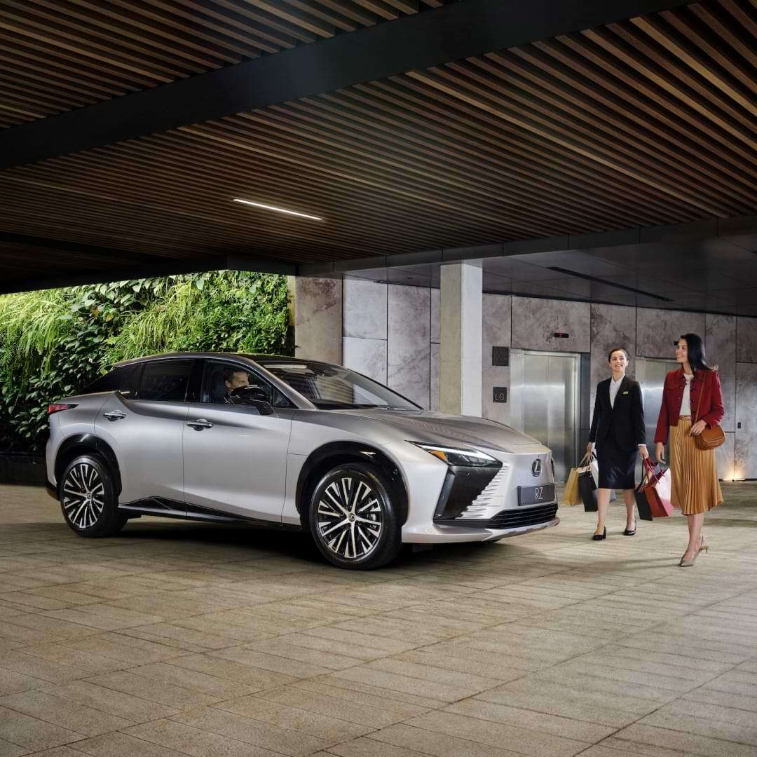 A well dressed lady collects her Lexus RZ from a valet parking service